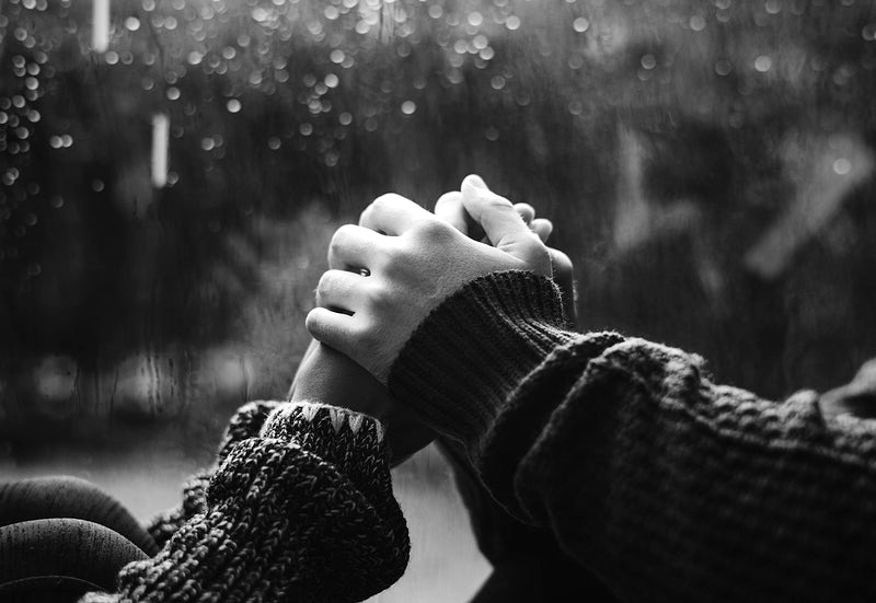 One-hand-holding-another-in-the-rain.